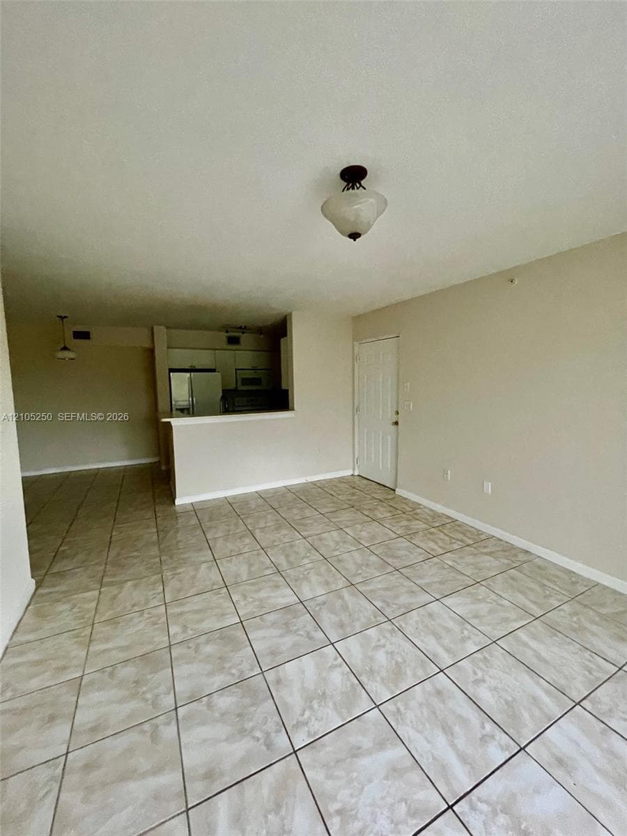 Expansive floorplan featuring light-toned tile flooring, neutral wall tones, and a semi-flush mount ceiling fixture