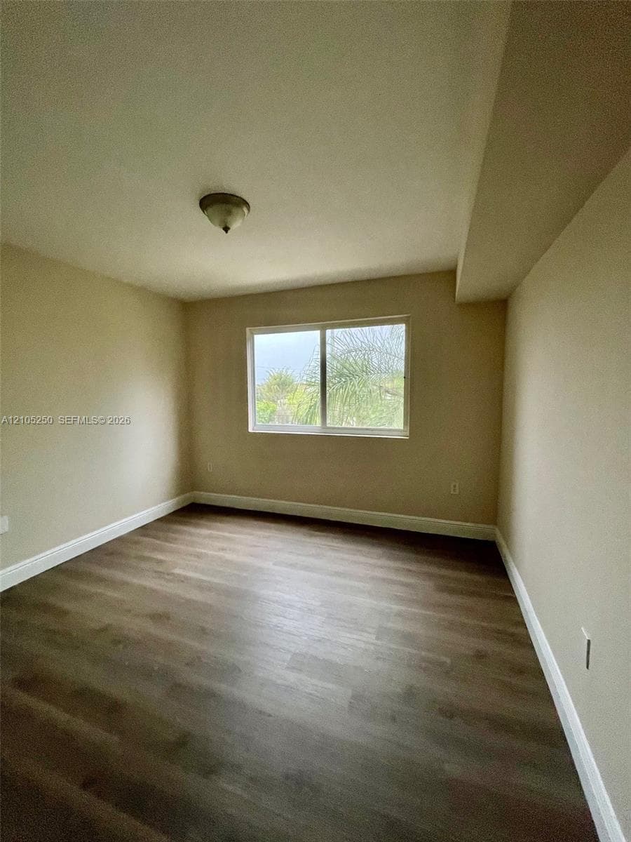 Wood-finish flooring, neutral wall tones, and a ceiling-mounted light fixture