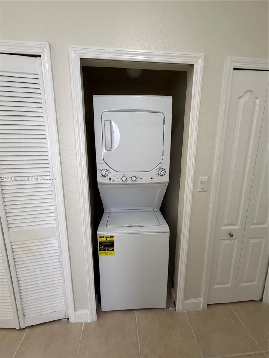 Stackable washer and dryer unit, louvered closet doors, and tiled flooring