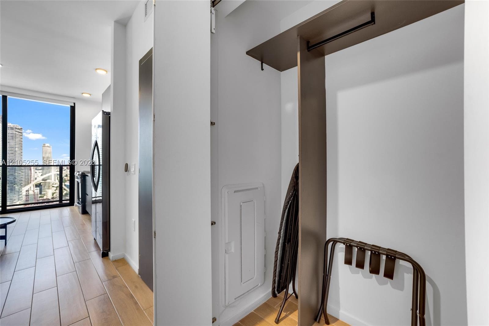 Floor-to-ceiling windows, wood-finish flooring, and built-in closet shelving