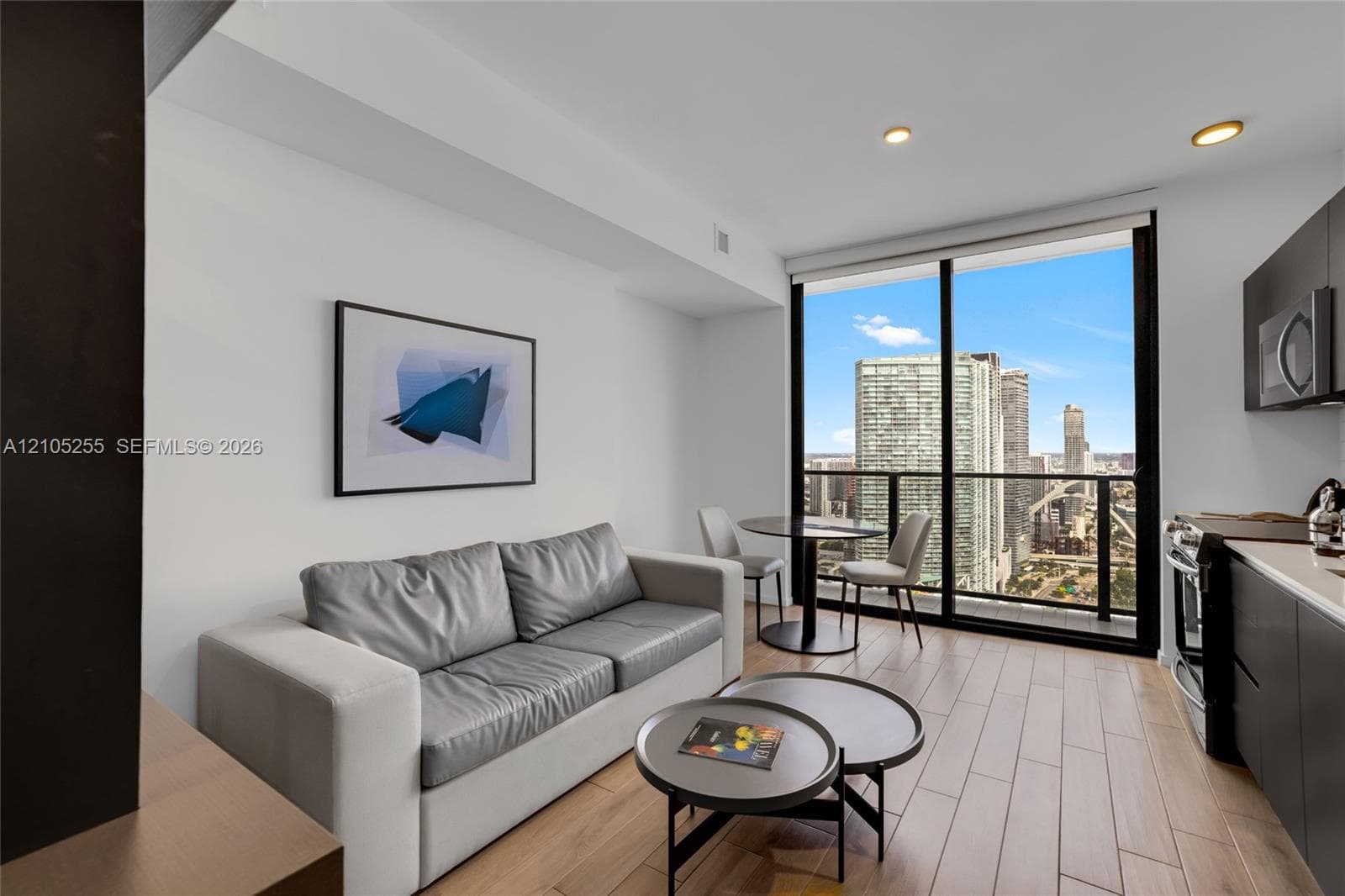 Floor-to-ceiling windows, wood-finish flooring, recessed lighting, and flat-panel cabinetry