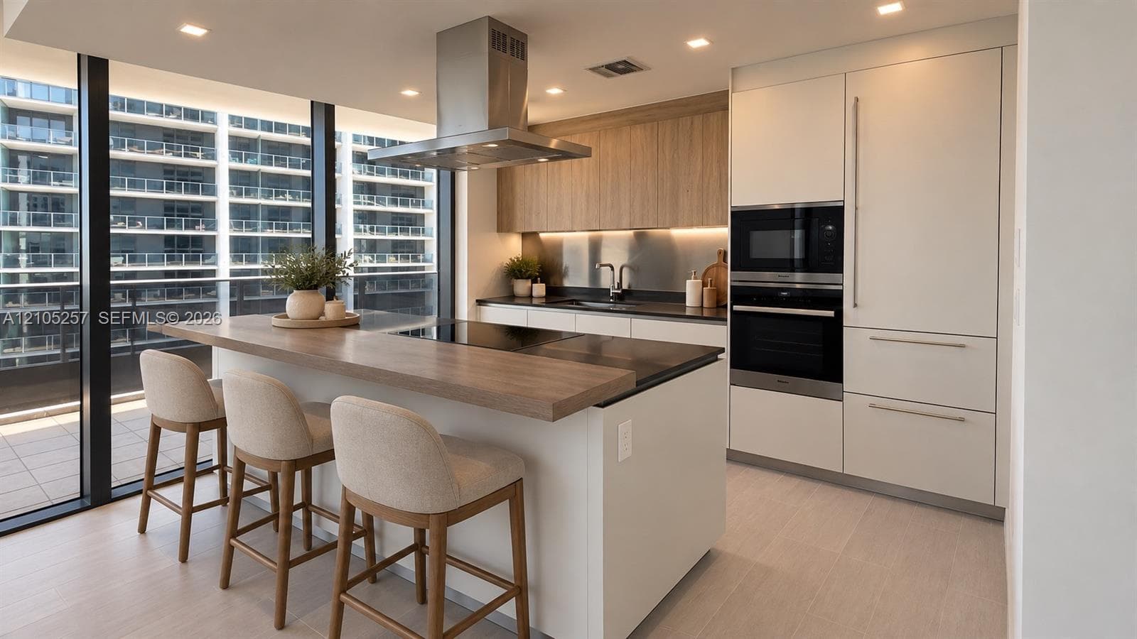 Contemporary kitchen featuring flat-panel cabinetry, a stainless steel range hood, integrated wall oven, and a kitchen island with a wood-finish surface