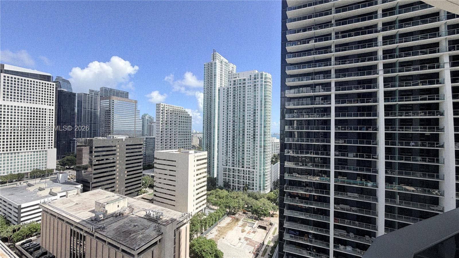 High-rise balcony featuring a glass-panel railing and extensive cityscape surroundings
