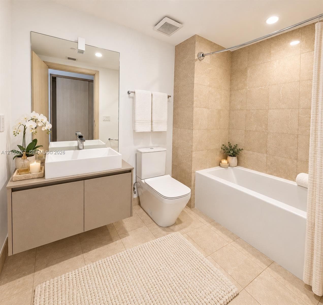 Floating vanity with a rectangular vessel sink and polished chrome faucet, floor-to-ceiling tile shower surround, and large-format tile flooring