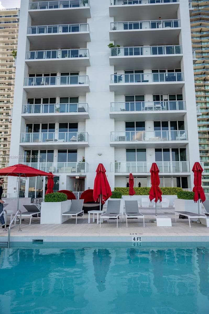 Outdoor swimming pool with a 4-foot depth marker, surrounded by a light-toned deck