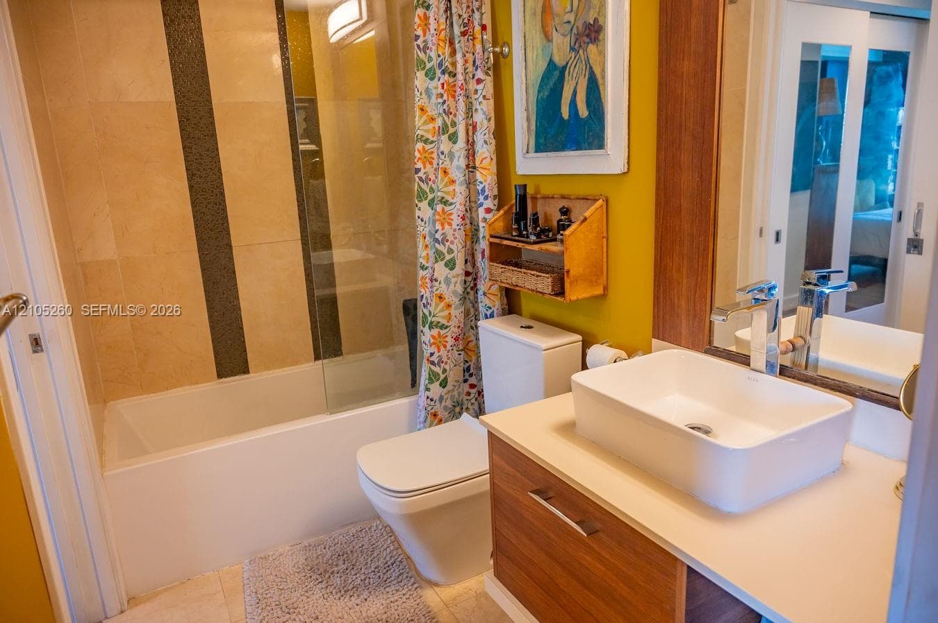 Tub and shower combination with tile surround, modern vanity with vessel sink, and chrome faucet