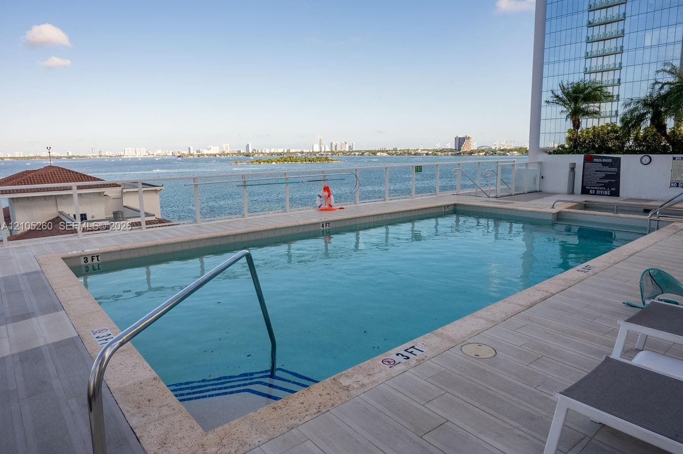 Rooftop pool with water scenery, integrated spa, and tile surround