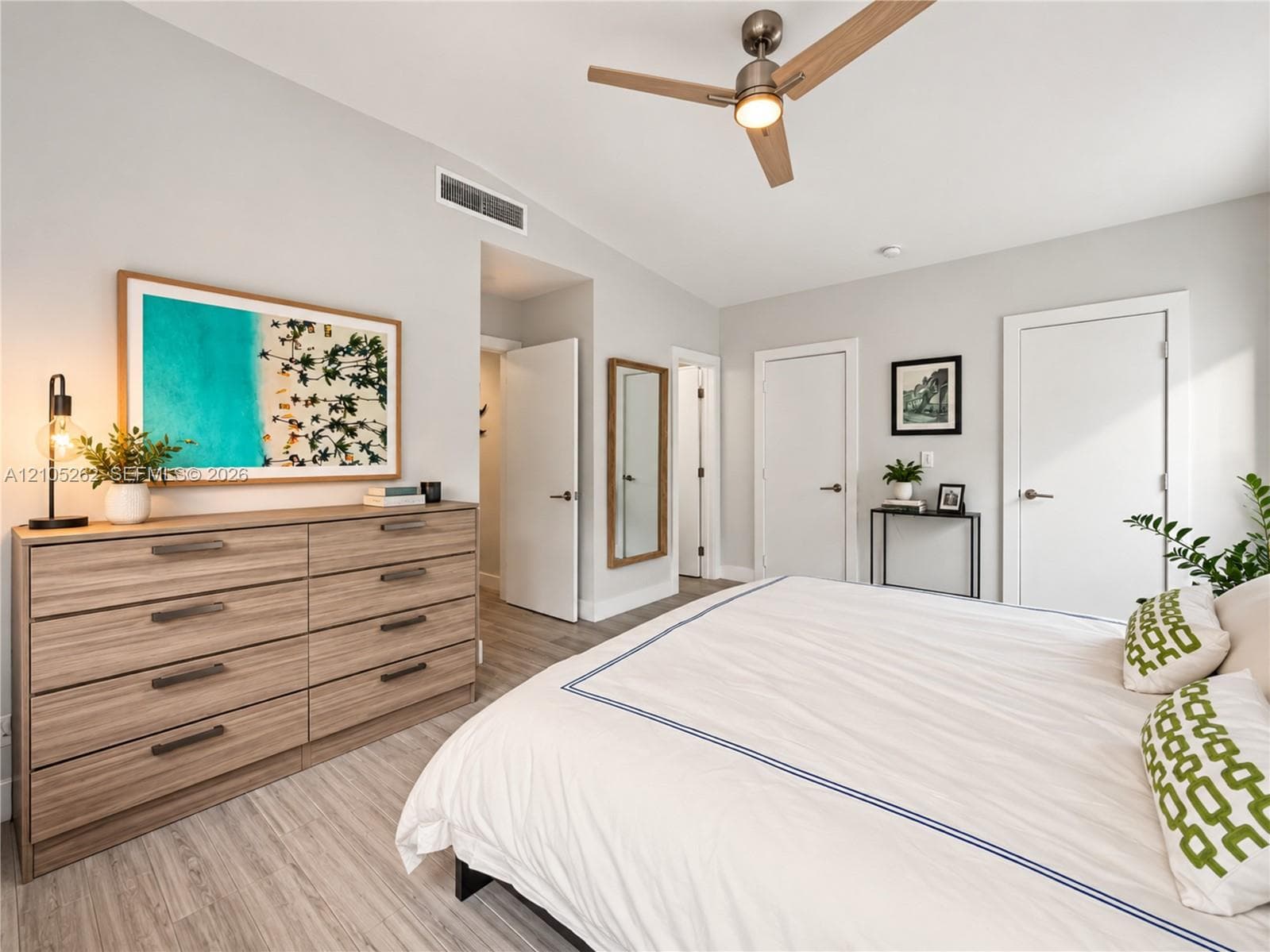 Light wood-finish flooring, vaulted ceiling, and recessed lighting