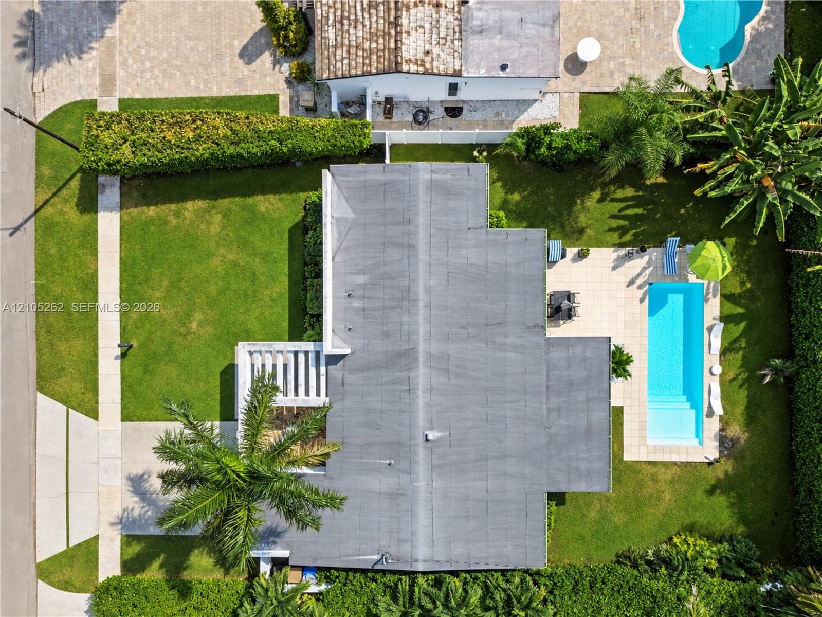 Rectangular swimming pool with integrated steps, surrounding patio, and manicured lawn