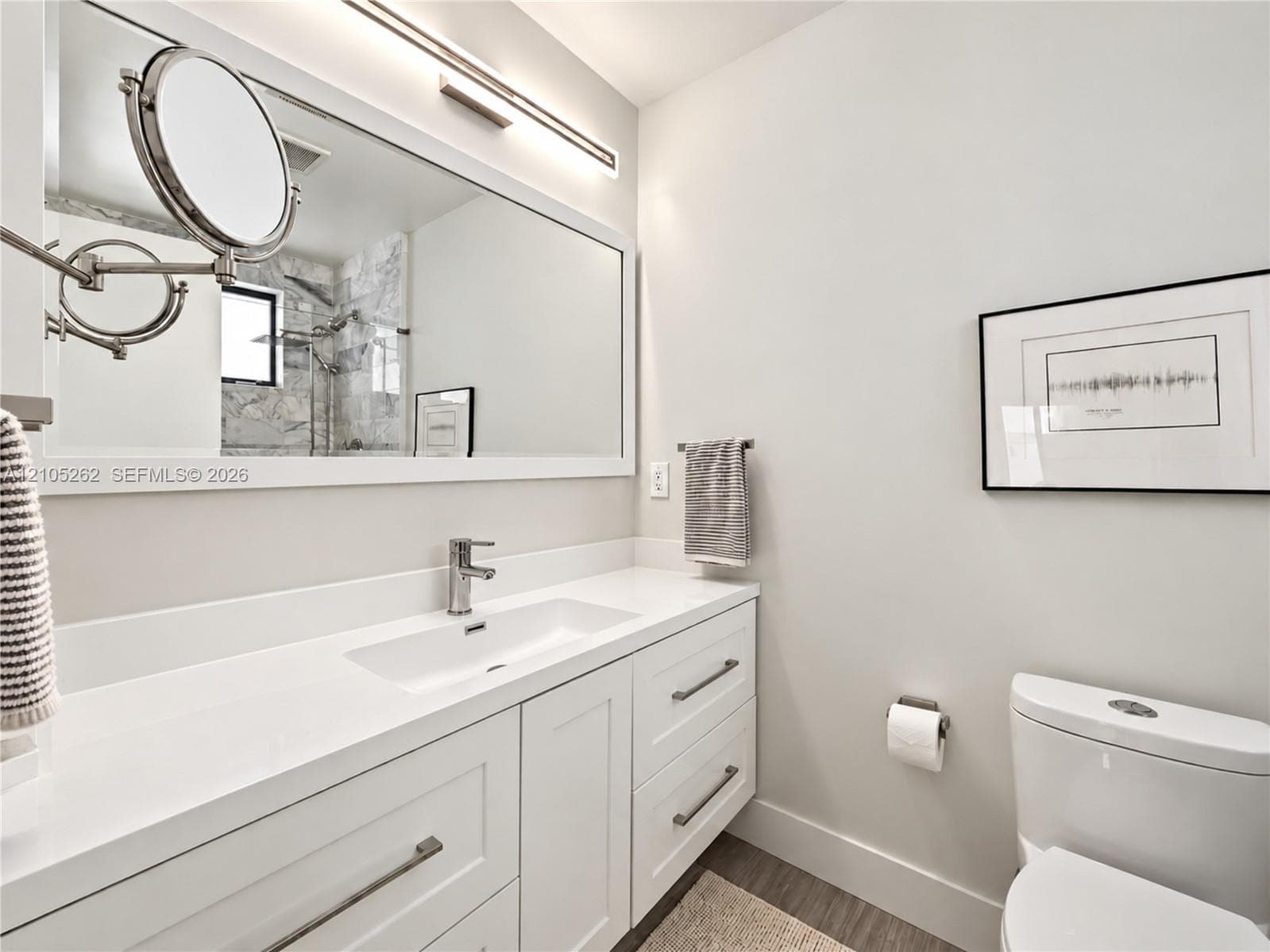 Vanity with an integrated rectangular sink, sleek chrome faucet, and expansive wall mirror