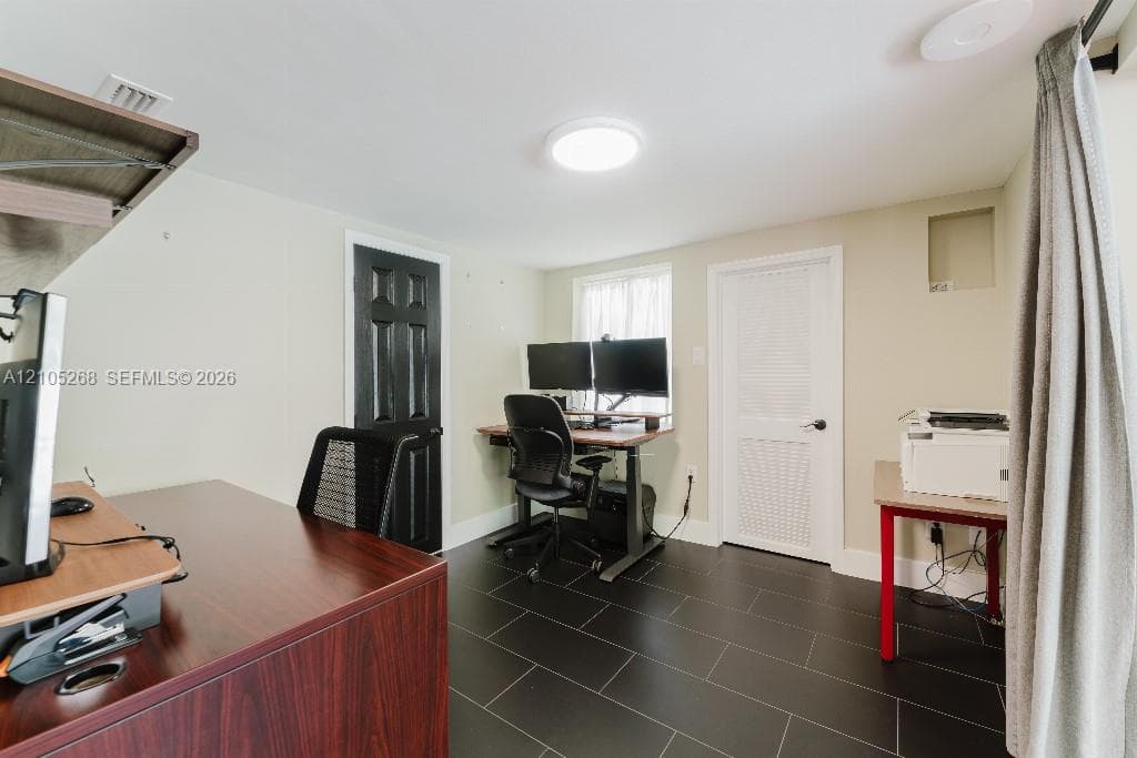 Black tile flooring, recessed lighting, and light neutral wall finishes