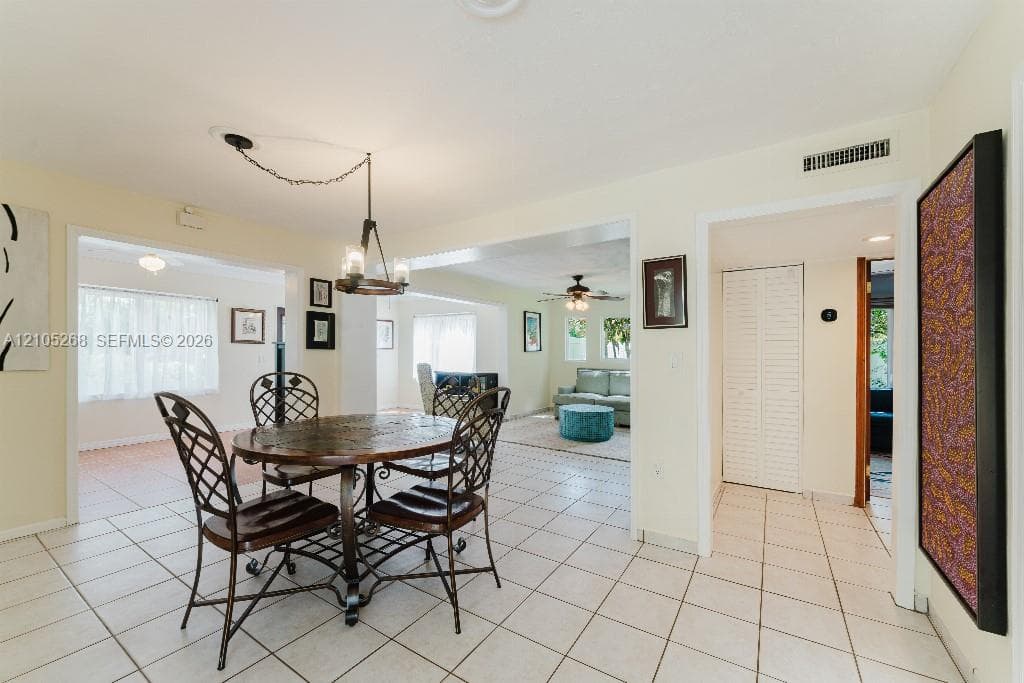 Tile flooring extends throughout this space, featuring an exposed beam ceiling and recessed lighting