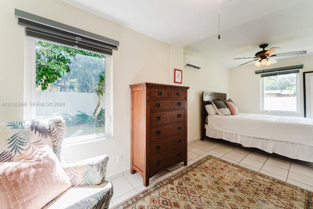 Tile flooring, ceiling fan with integrated lighting, split air conditioning system, and window with privacy blinds