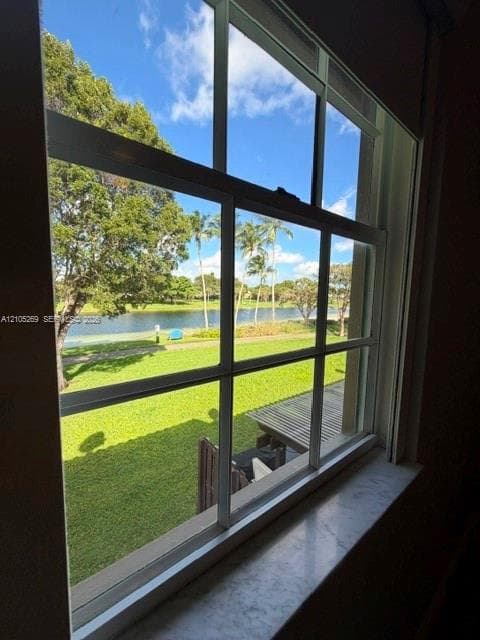 White-framed window with muntins, featuring a stone window sill and a water view