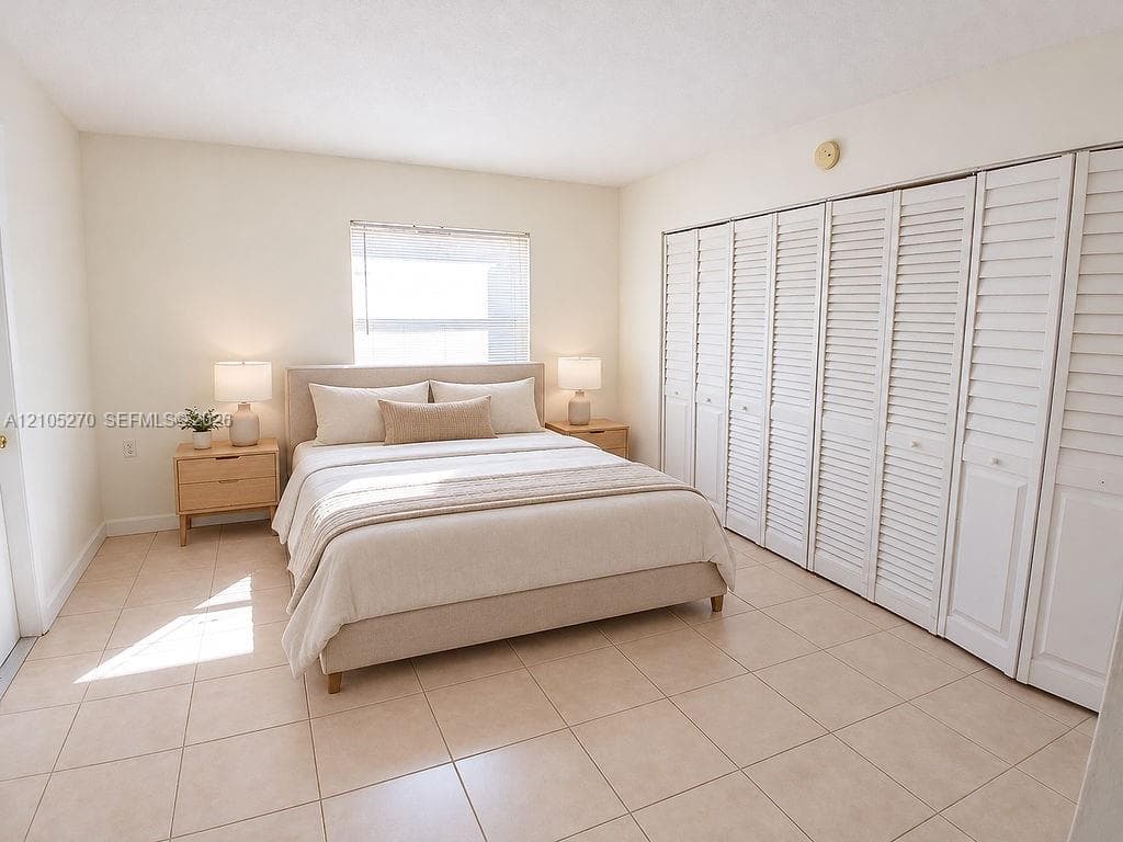 Light-toned tile flooring, louvered closet doors, and recessed window