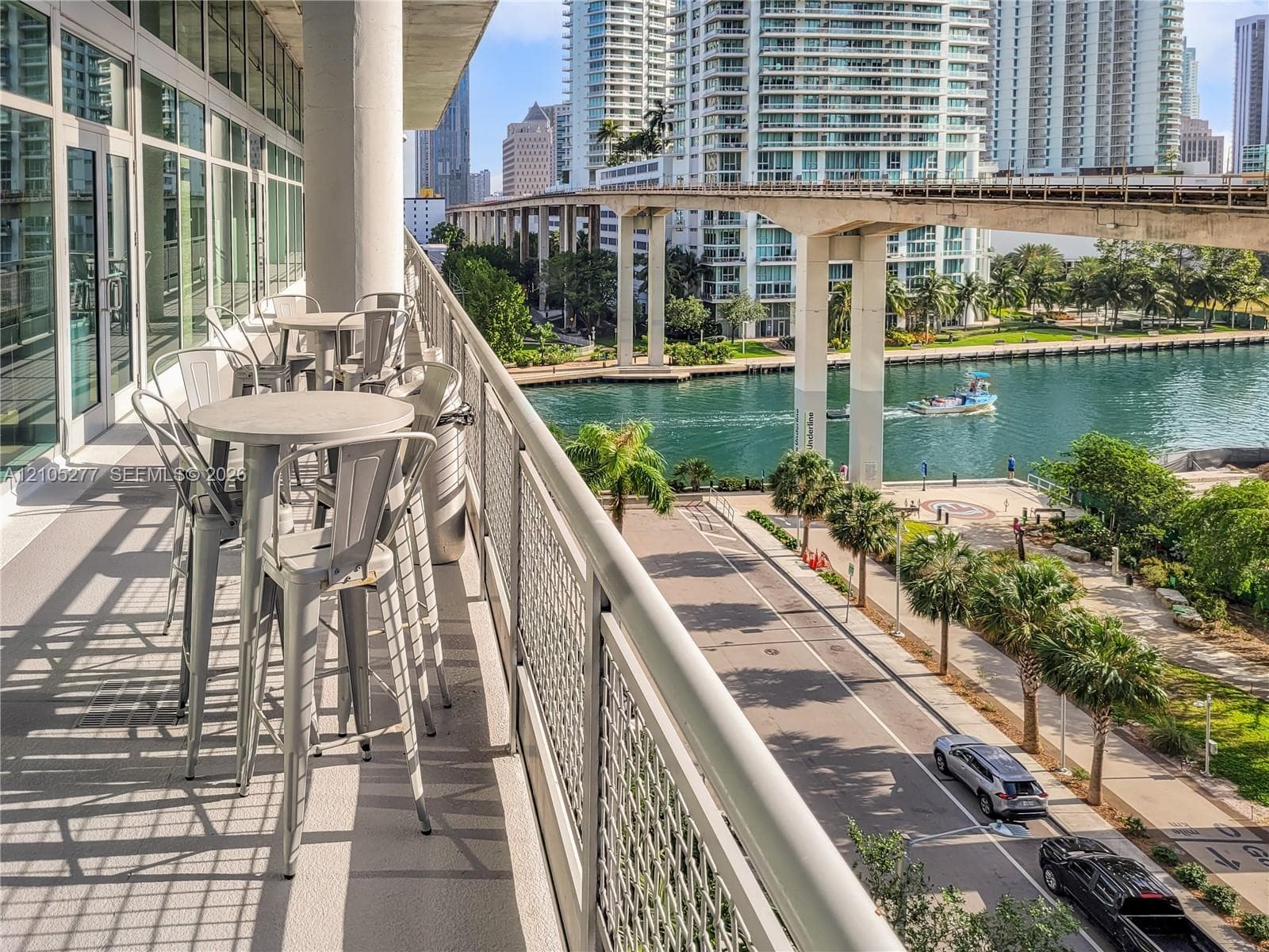Expansive balcony with a mesh railing system, providing an open-air extension to the interior space through large glass doors