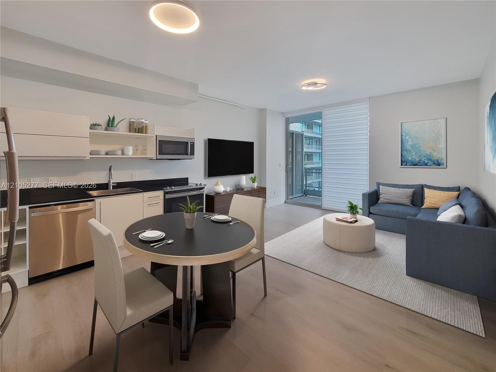 Open-concept living space with wood-finish flooring, recessed lighting, and a sliding glass door