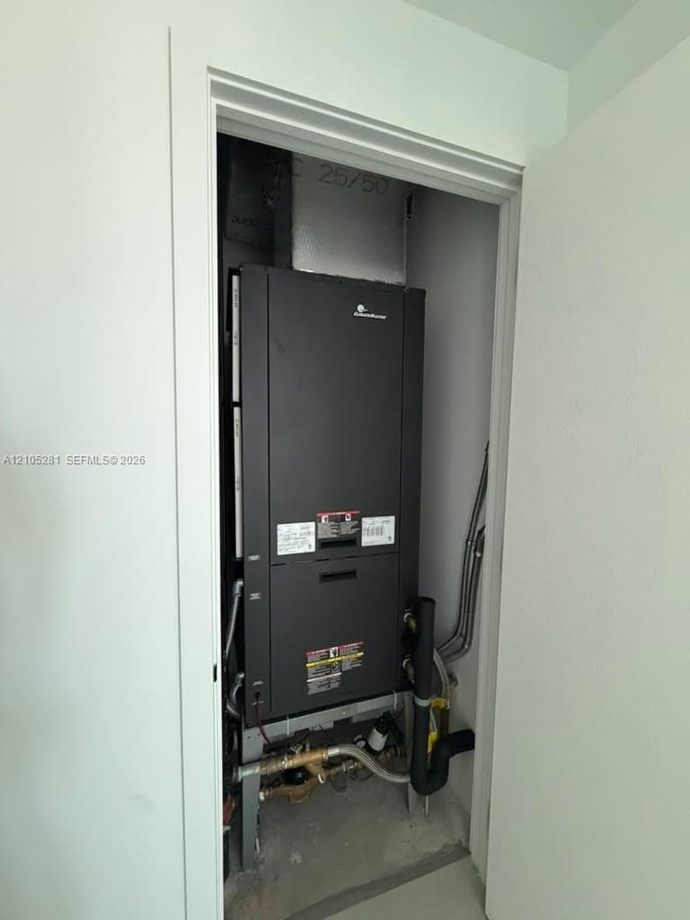 Dedicated utility closet housing a vertical HVAC air handler unit with integrated plumbing and gas line connections