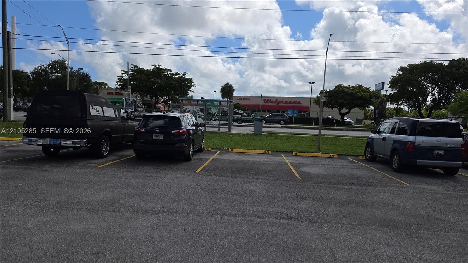 Asphalt parking area featuring painted yellow stall markers and designated curbing