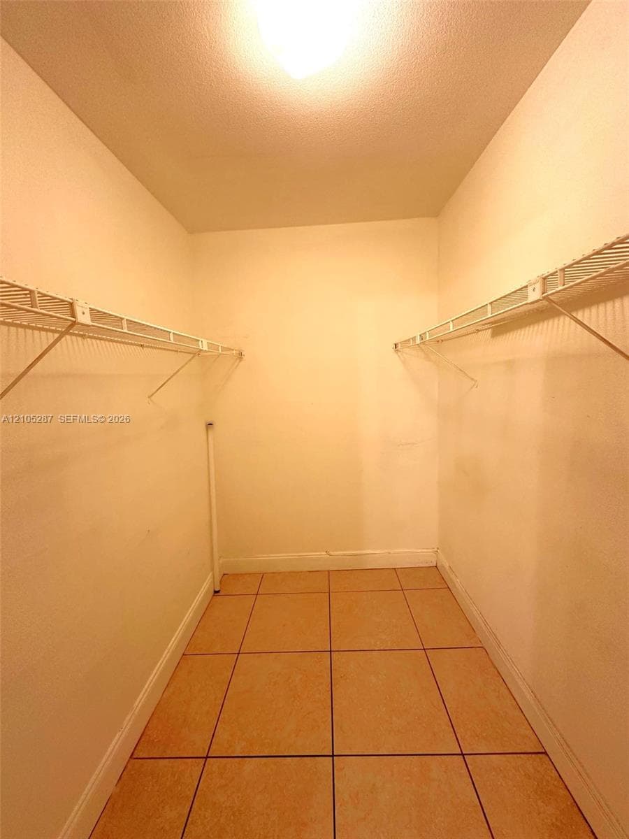 Tile flooring, built-in wire shelving, overhead lighting