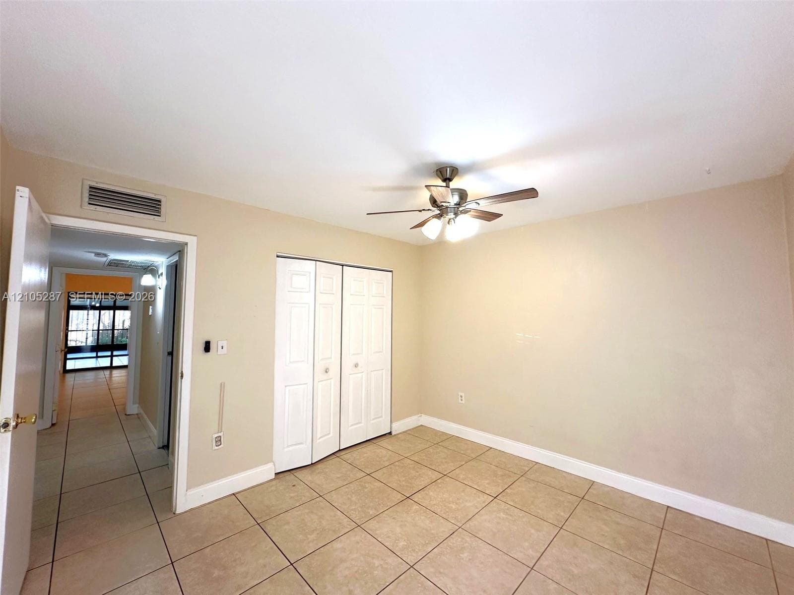 Ceiling fan with integrated lighting, tile flooring, bi-fold closet doors, and light-toned walls