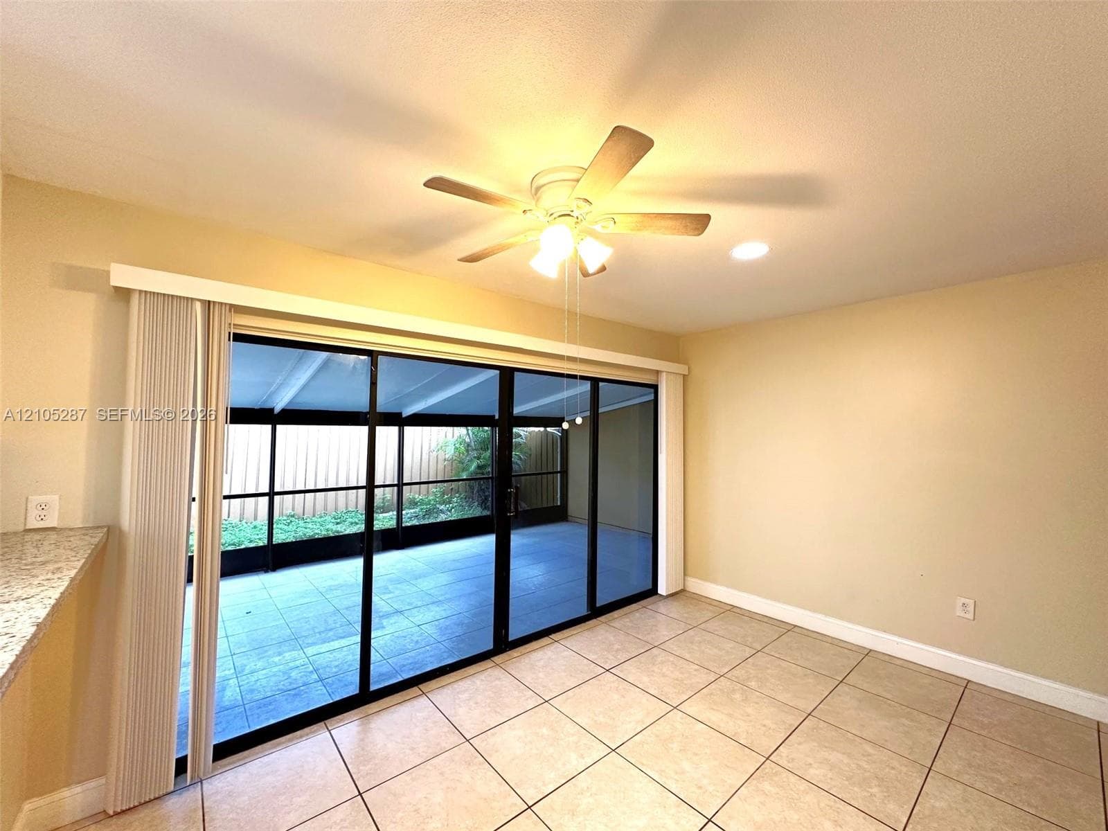 Tile flooring throughout, with a ceiling fan and recessed lighting