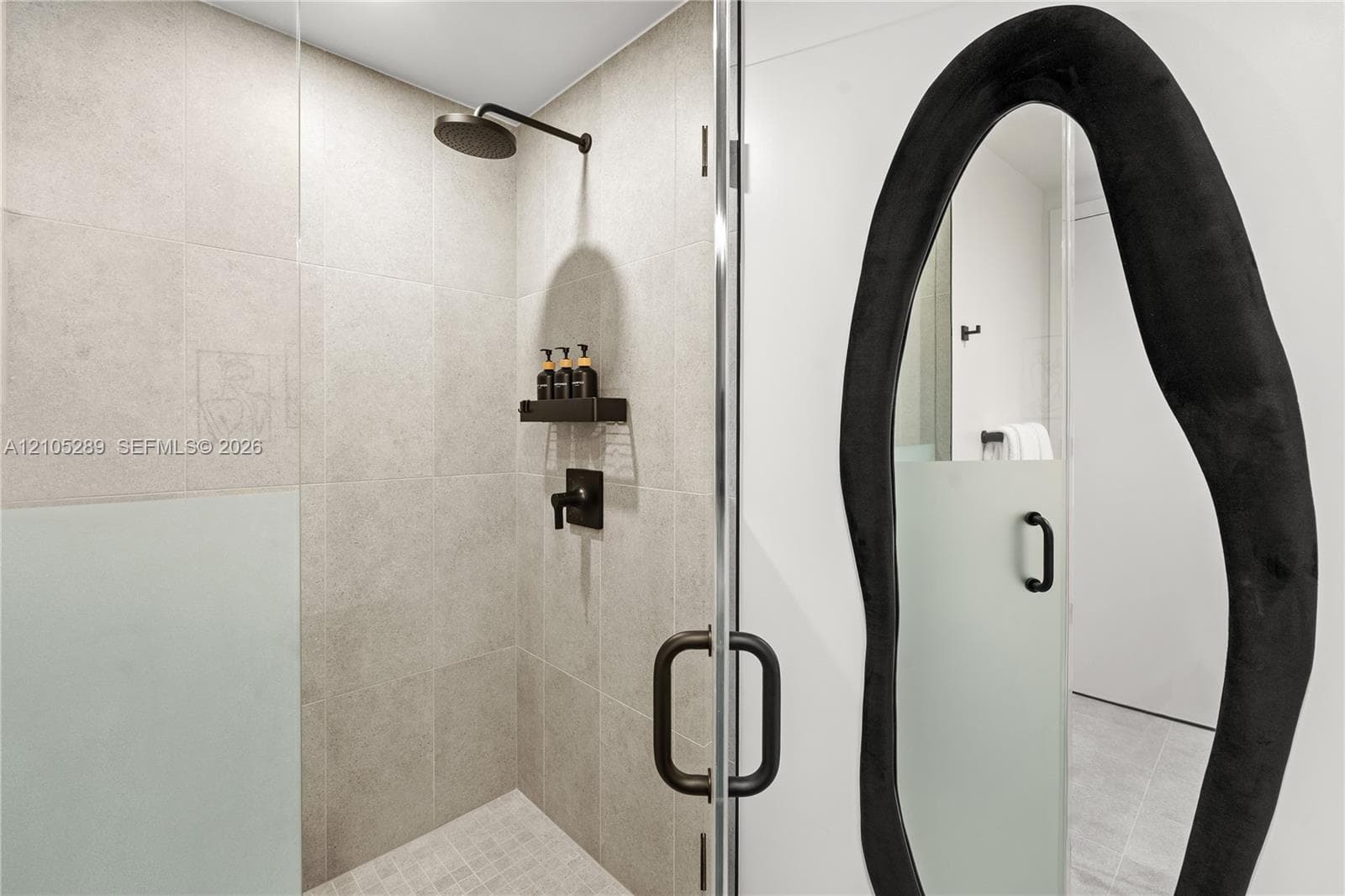 Walk-in shower with clear glass enclosure and black hardware