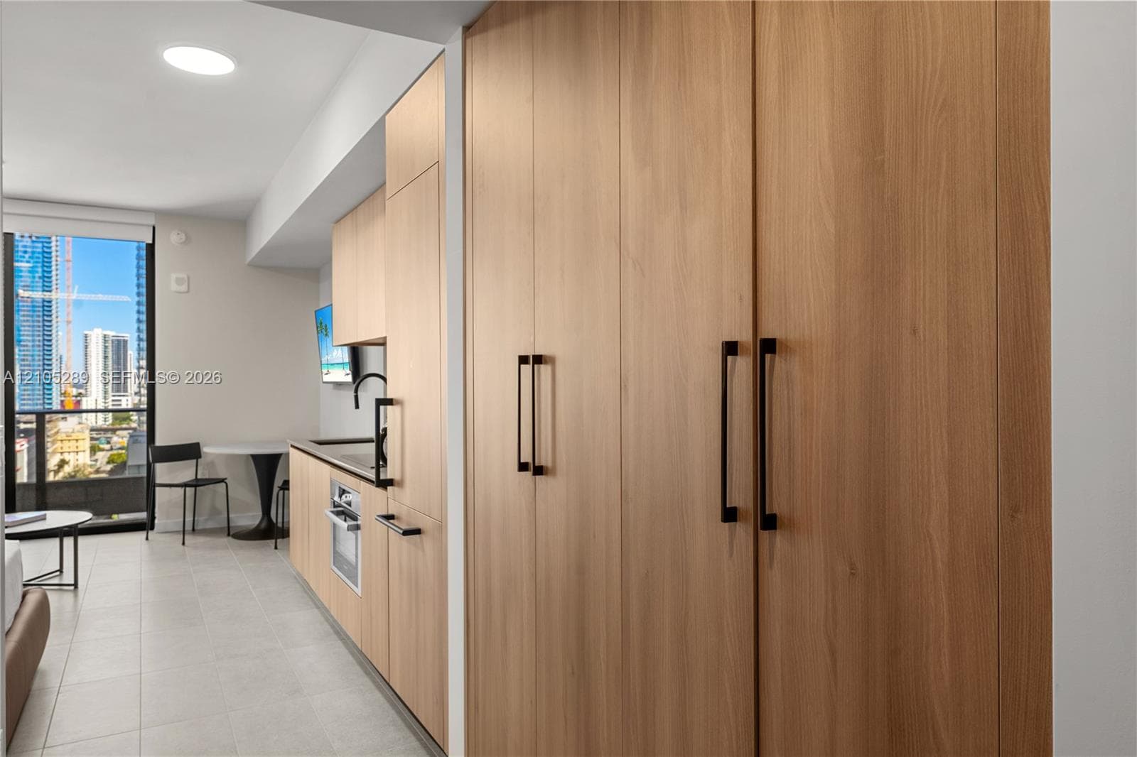 Integrated kitchen with wood-finish cabinetry and matte black hardware