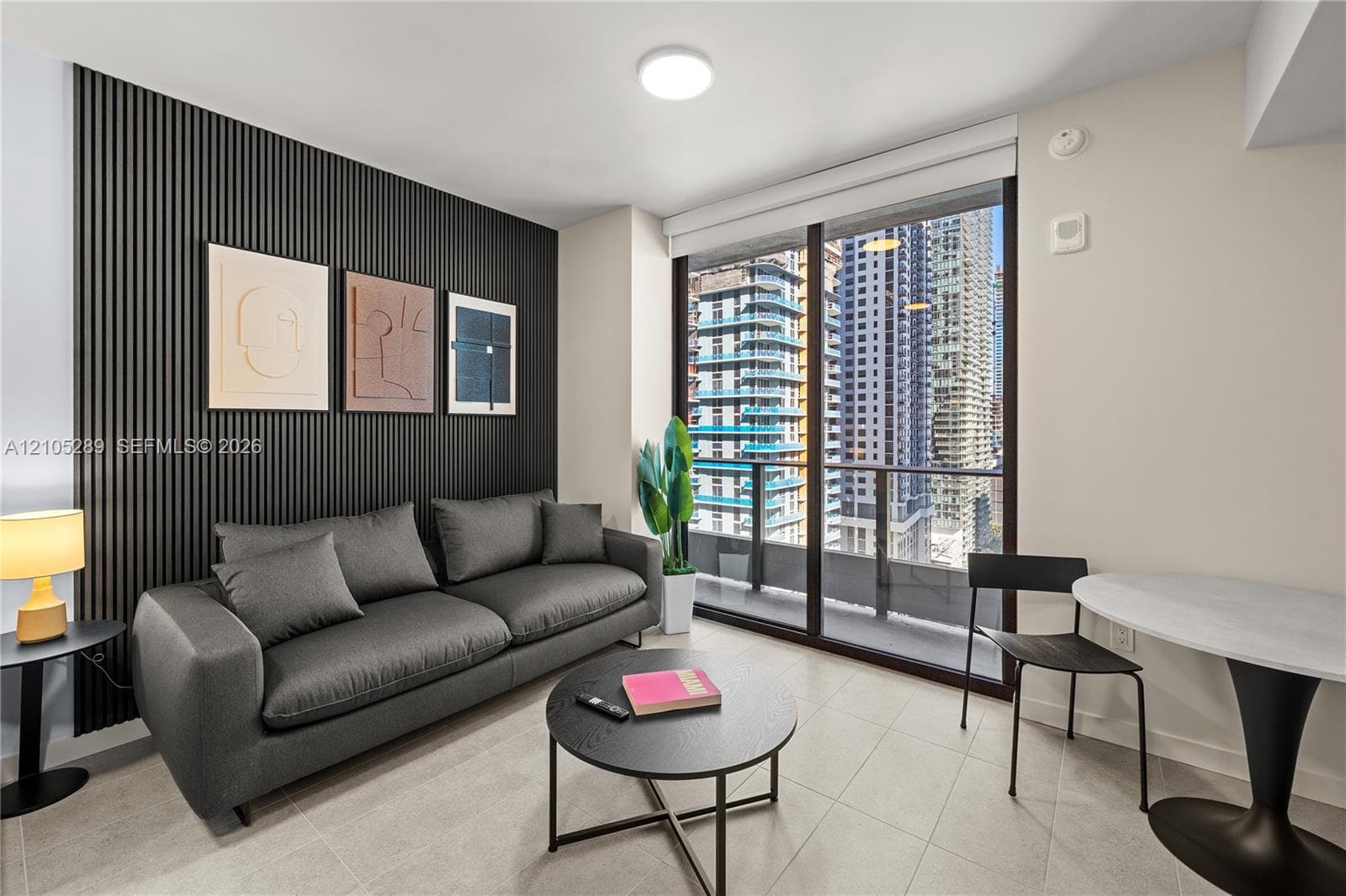 Floor-to-ceiling glass doors, private balcony, and a paneled accent wall with integrated ambient lighting