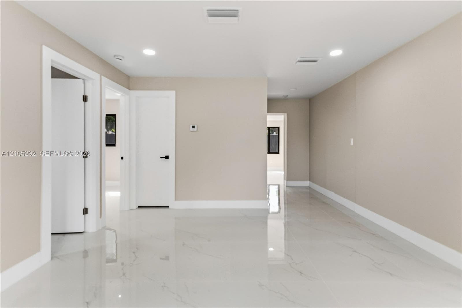 Recessed ceiling lighting, white interior doors, bright white flooring, and light-toned wall finishes