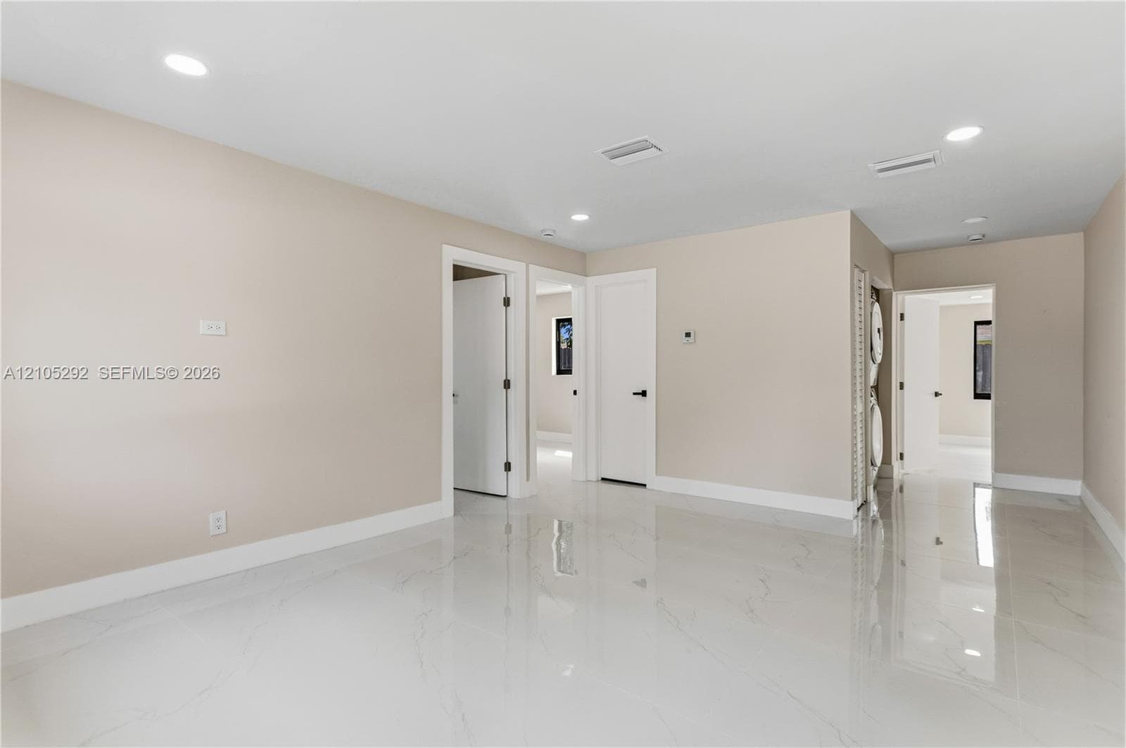 Recessed lighting illuminates the neutral wall tones and white trim