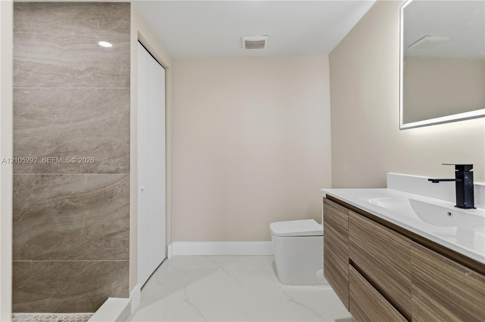 Floating wood-finish vanity with an integrated sink and matte black faucet