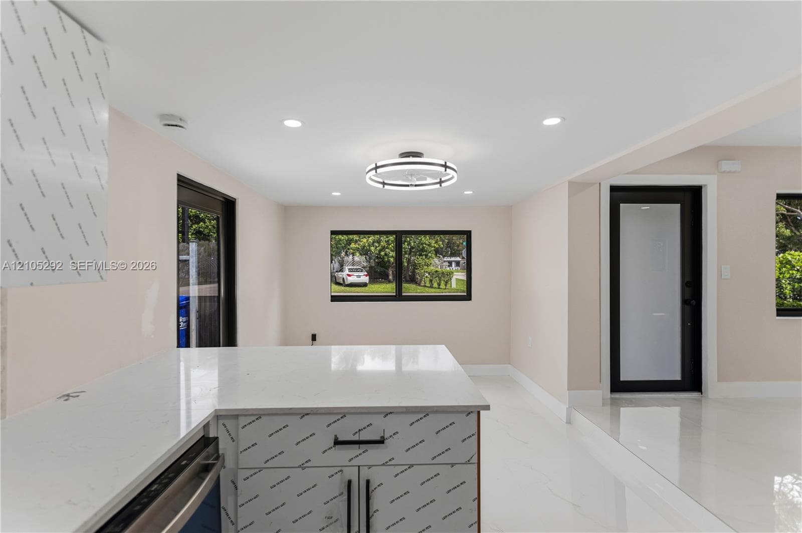 White countertop island with built-in cabinetry and matte black hardware