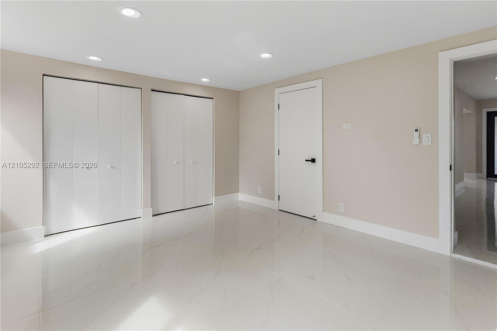 Recessed lighting, light-toned walls, and white tile flooring