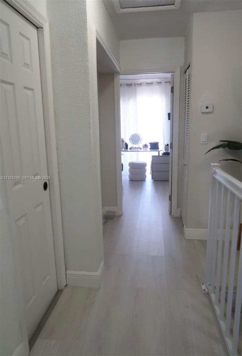 Wood-finish flooring throughout, white interior doors, and white painted balusters