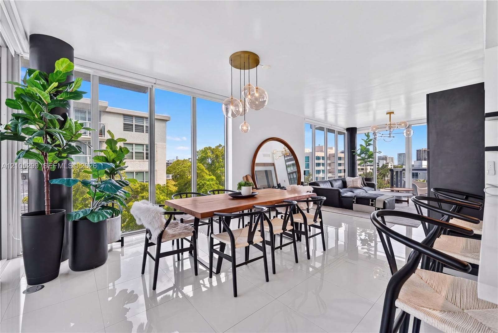Expansive living space with white tile flooring, floor-to-ceiling windows, and a multi-light pendant fixture
