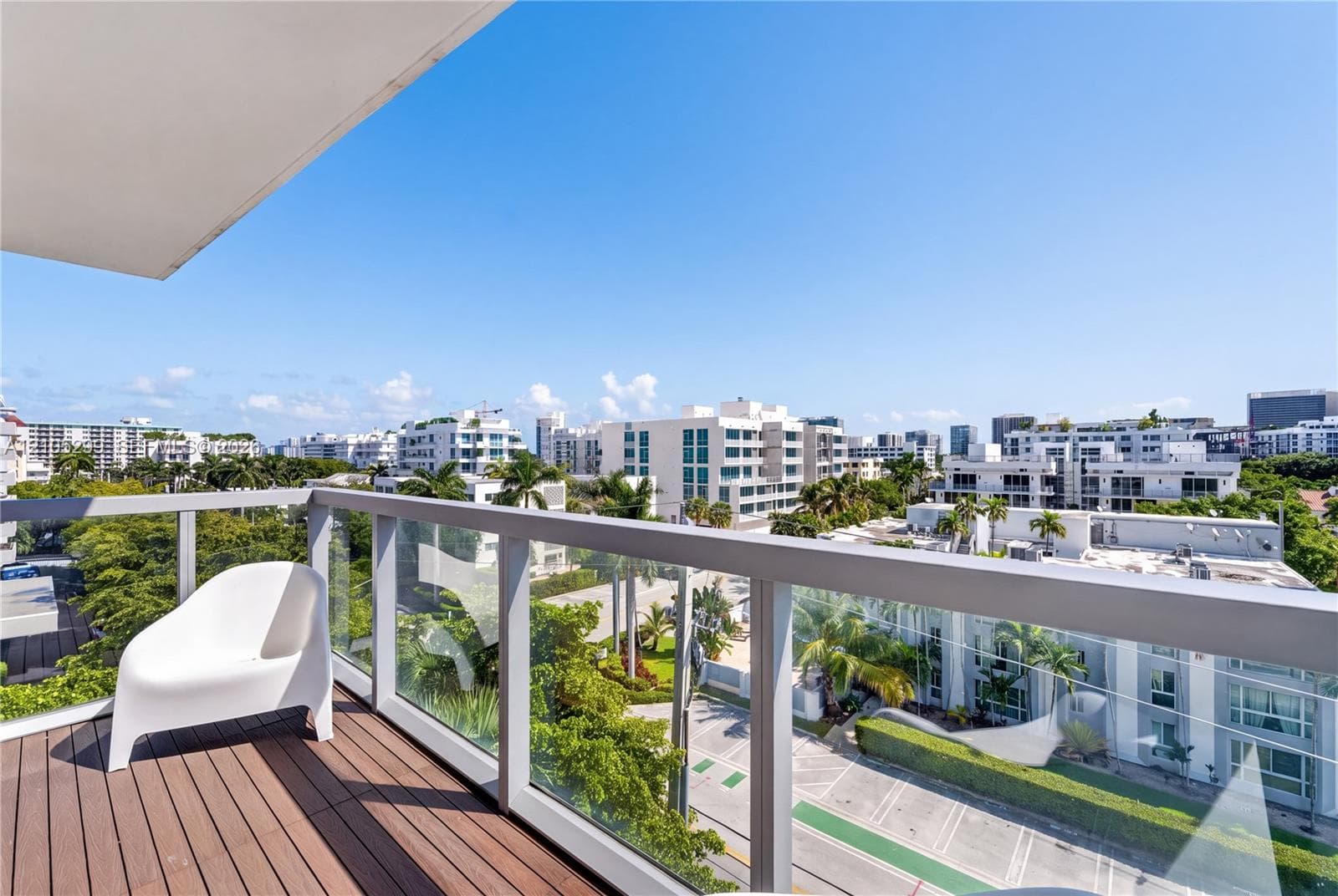 Balcony featuring wood-finish decking and clear glass panel railing