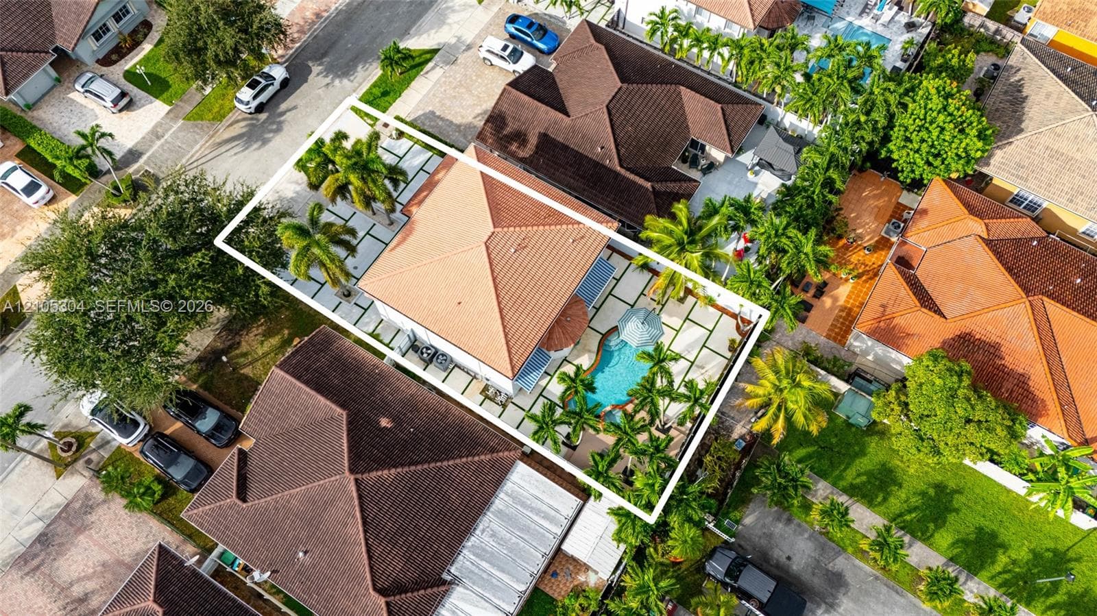 Aerial perspective featuring a tile roof, an in-ground swimming pool, and a hardscaped patio with concrete pavers