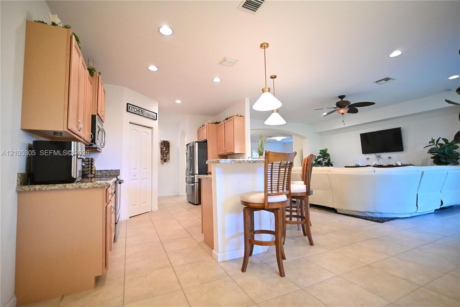 Kitchen featuring recessed lighting, wood-finish cabinetry, granite countertops, and stainless steel appliances