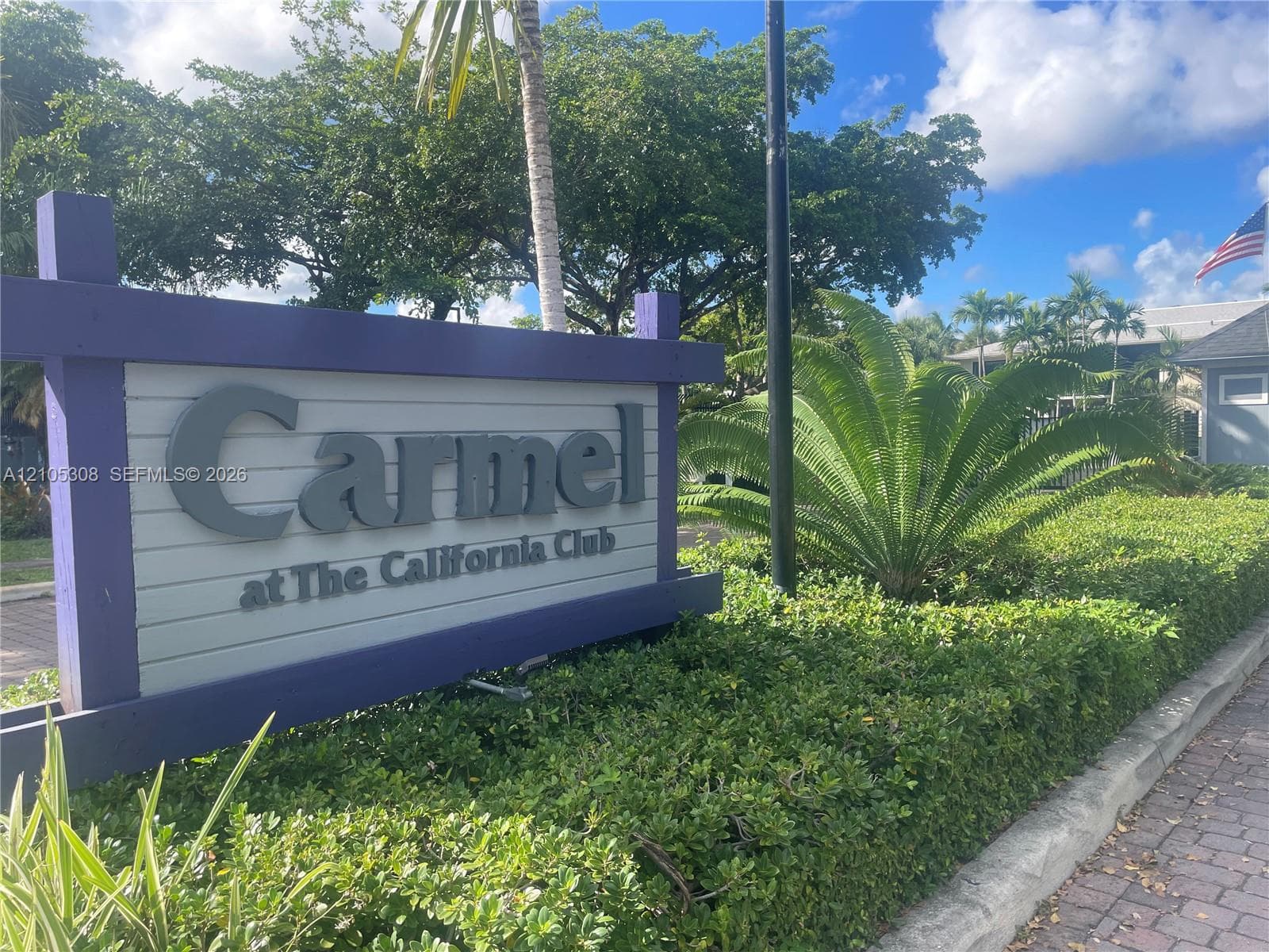 Community entrance signage featuring wood-frame construction and professional landscaping
