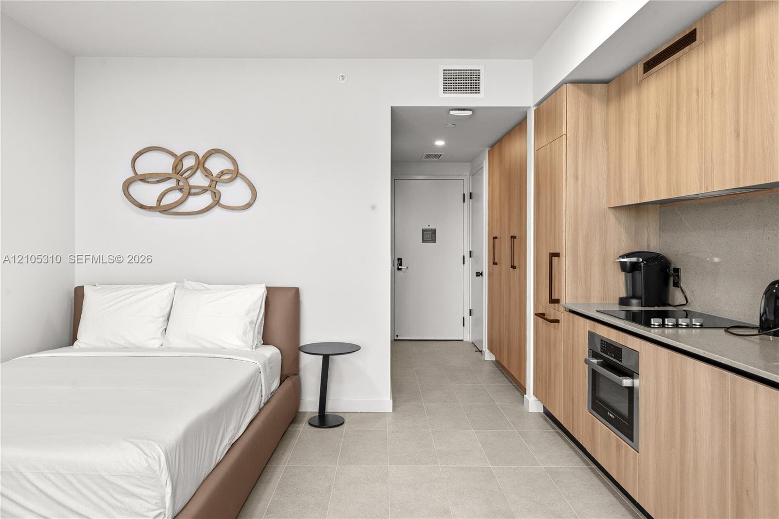 Integrated kitchen with wood-finish cabinetry and built-in appliances, light-toned flooring, and recessed lighting