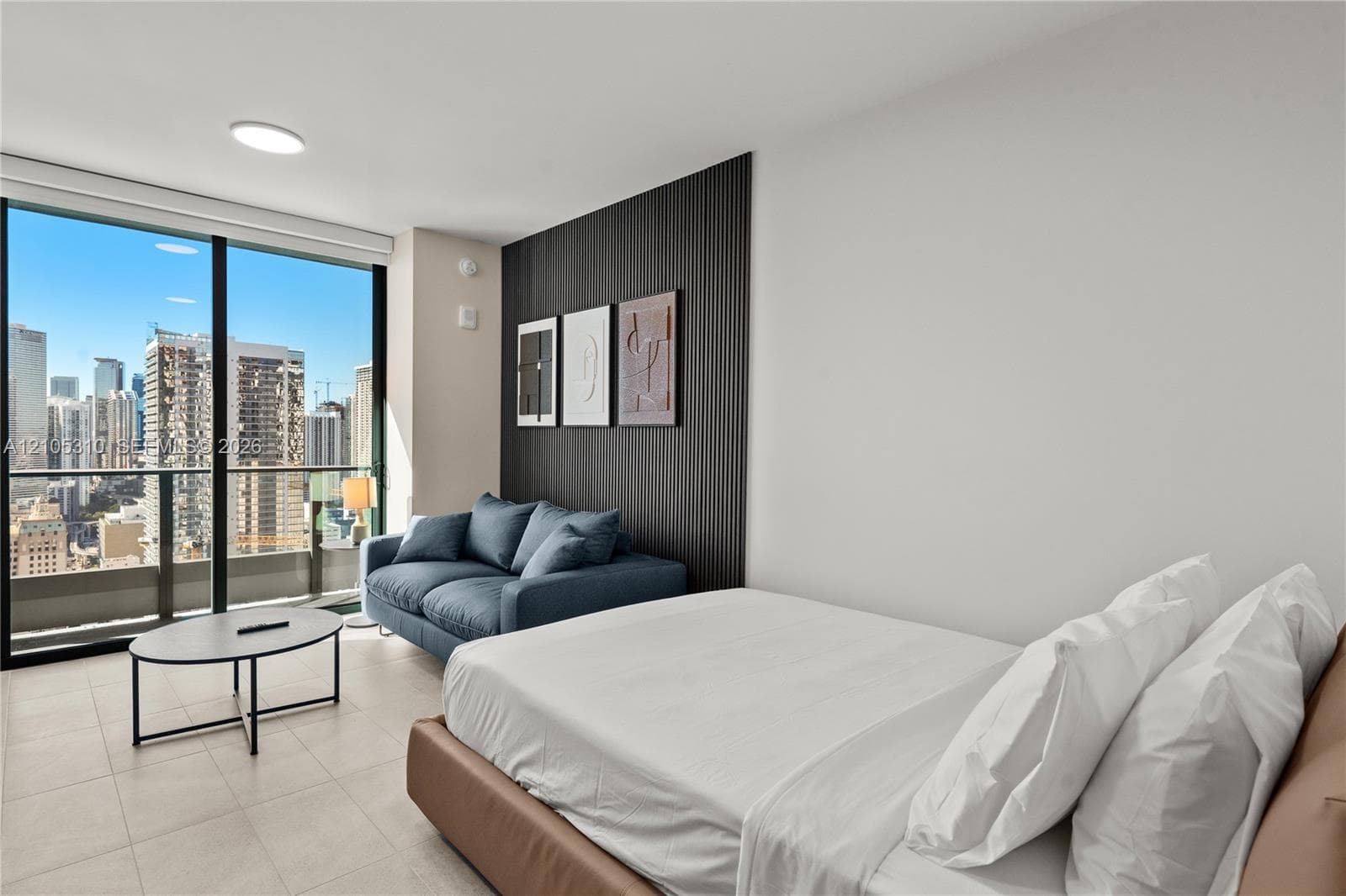 Floor-to-ceiling windows, city skyline, recessed lighting, and a textured accent wall
