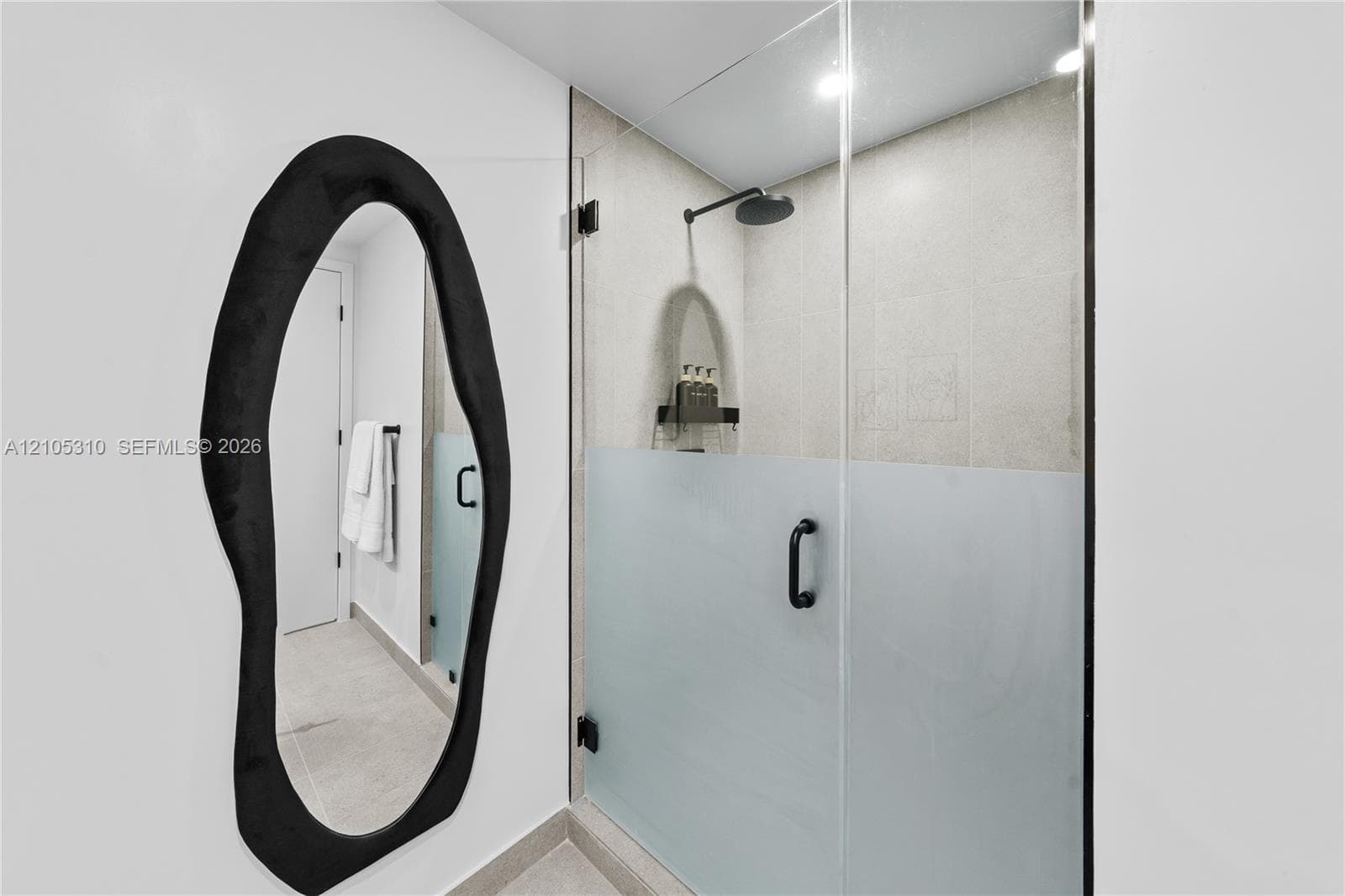 Glass-enclosed shower with a matte black rainfall showerhead