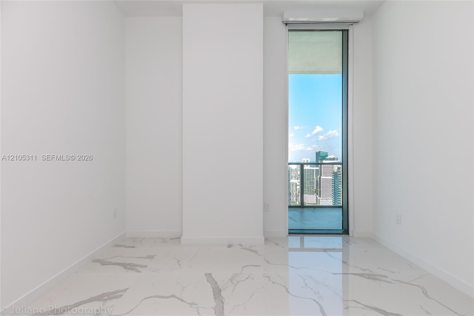 Full-height glass door with city backdrop, white walls, and polished tile flooring