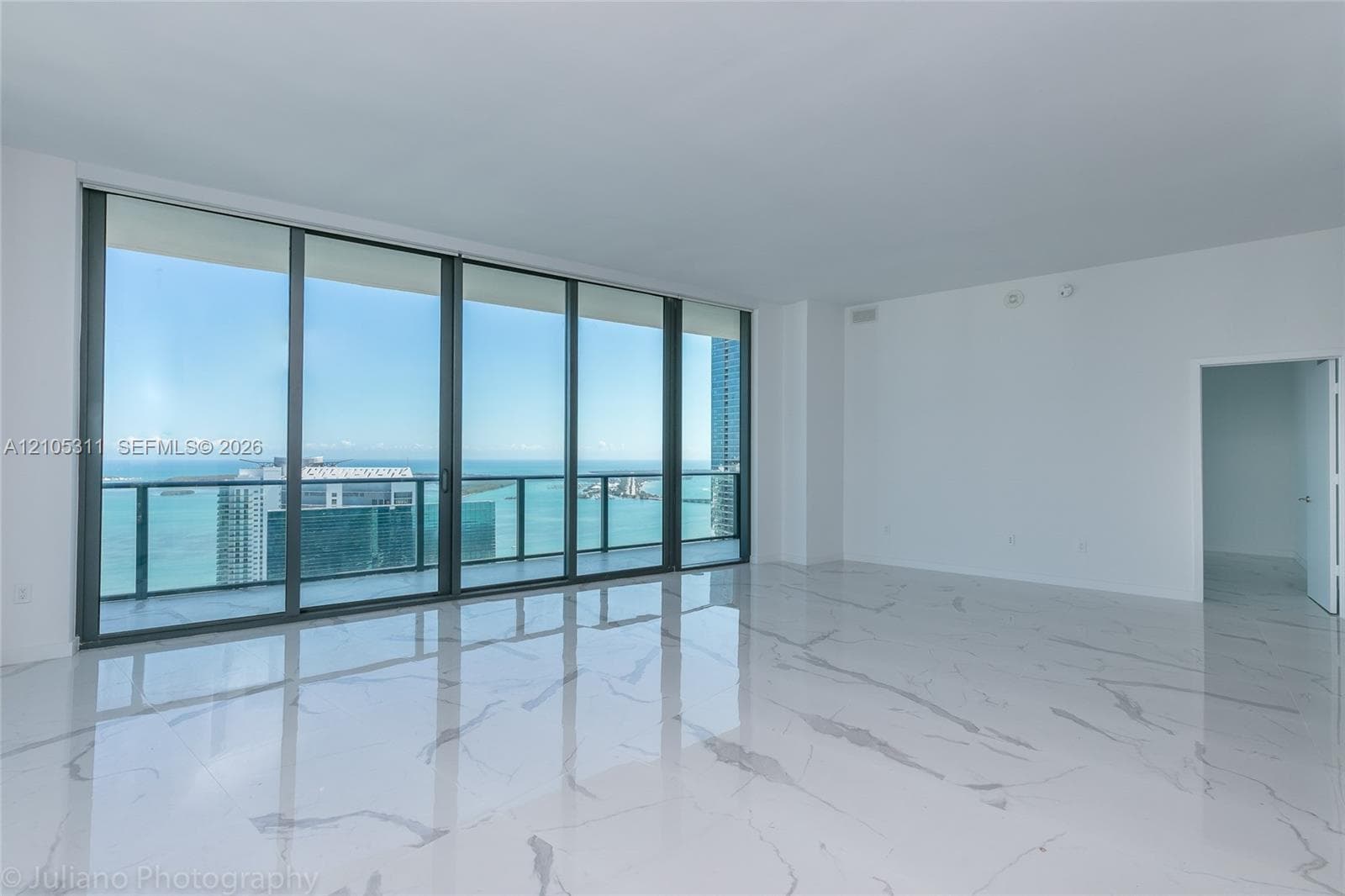Expansive room featuring large format tile flooring and floor-to-ceiling sliding glass doors