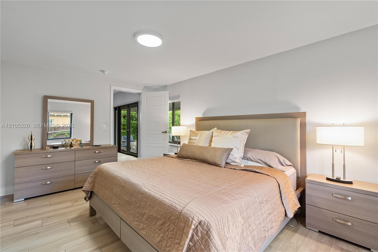 Recessed lighting, light wood-finish flooring, and a panel door leading to outdoor space