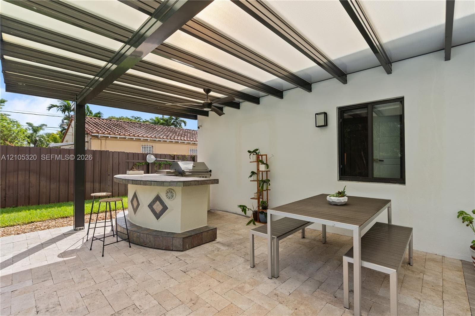 Covered patio with an outdoor kitchen, built-in grill, and ceiling fan