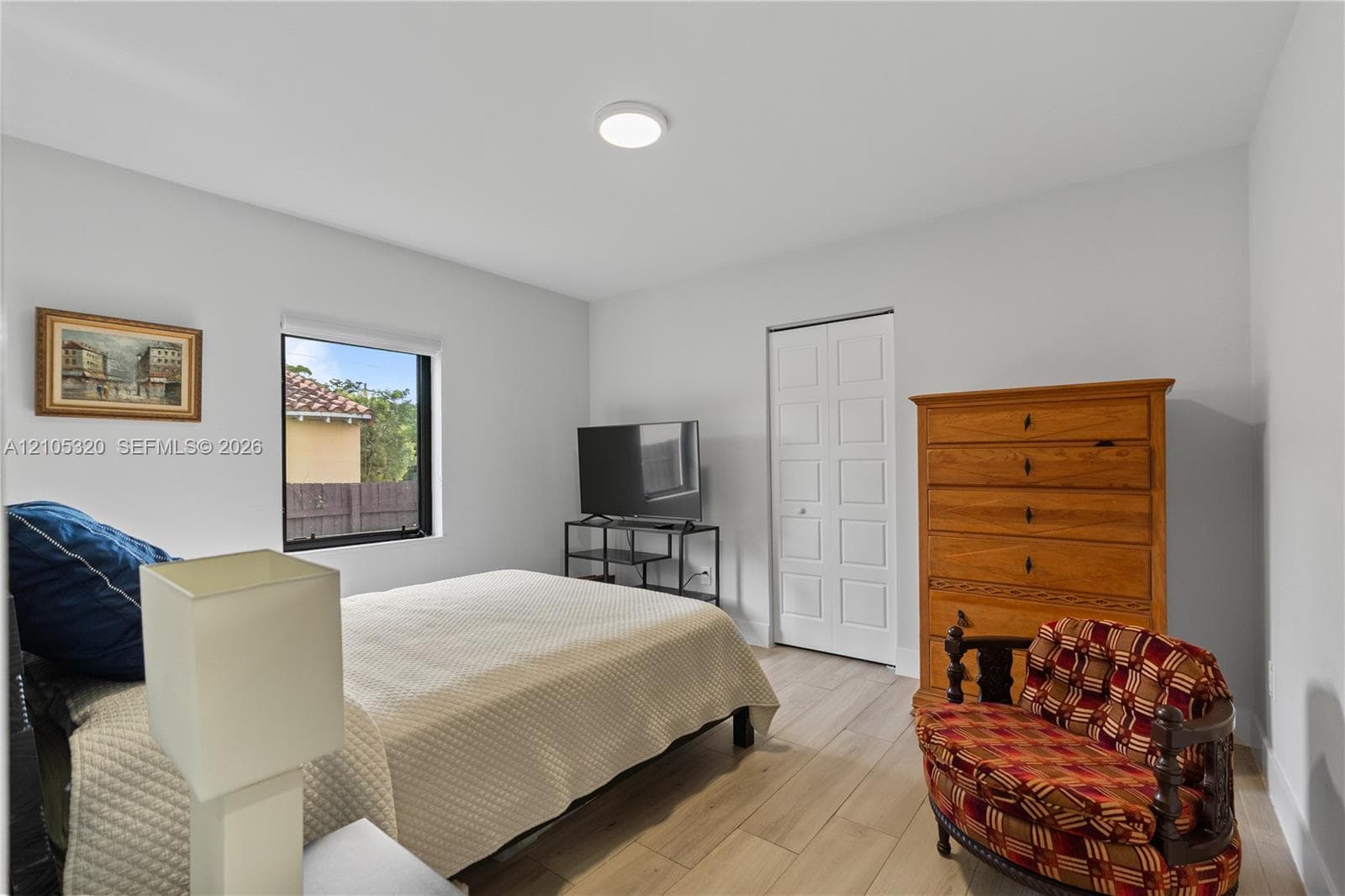 Recessed ceiling lighting, light wood-finish flooring, and a window with a black frame