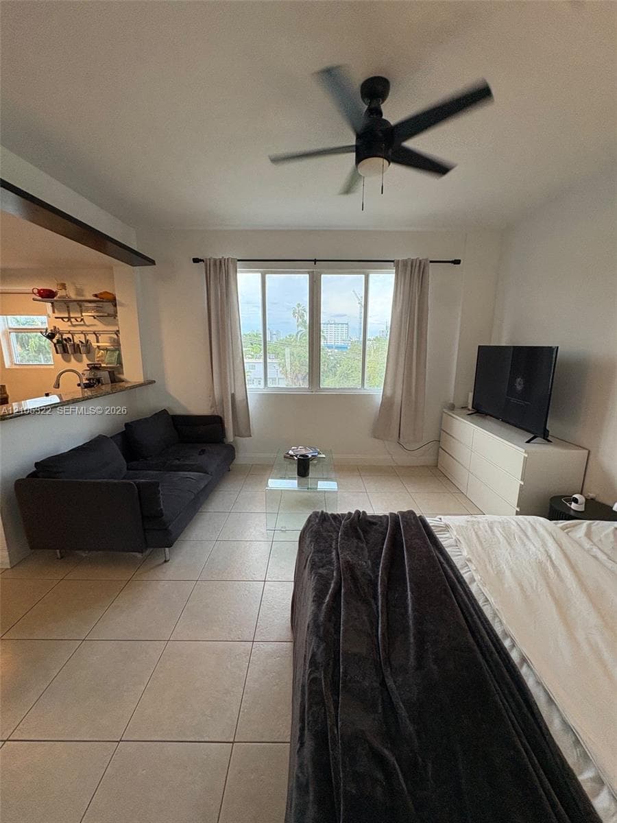 Open-concept living area with tile flooring and a ceiling fan