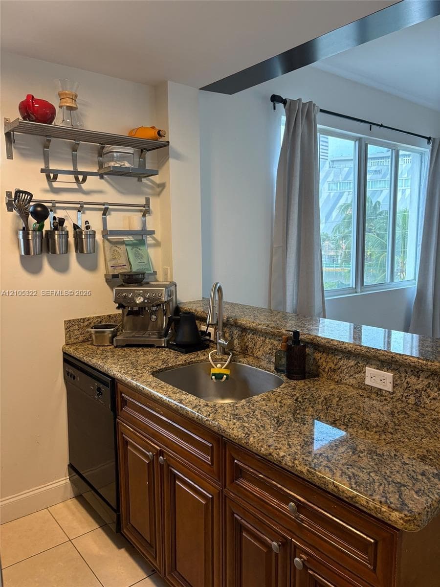 Granite countertops, stainless steel sink, wood-finish cabinetry, and a built-in dishwasher